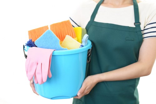 Professional home cleaner tidying a modern London living room